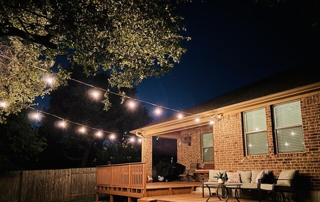 2217 Hilltop Climb Dr, Leander, TX 78641 - back of house at twilight featuring brick siding, an outdoor hangout area, and a wooden deck