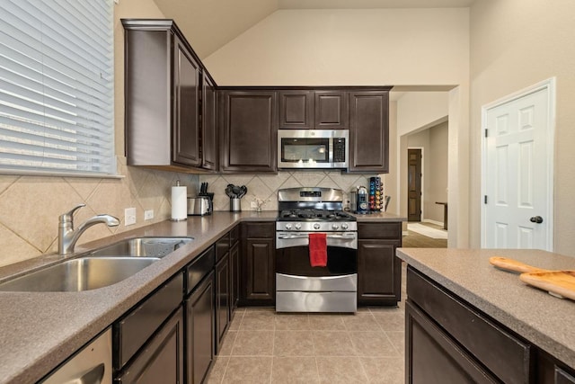 2217 Hilltop Climb Dr, Leander, TX 78641 - kitchen with appliances with stainless steel finishes, a sink, backsplash, dark brown cabinets, and vaulted ceiling