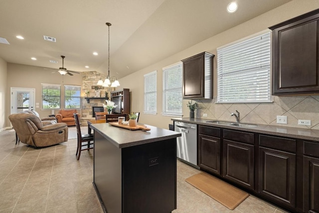 2217 Hilltop Climb Dr, Leander, TX 78641 - kitchen with stainless steel dishwasher, a sink, lofted ceiling, a kitchen island, and backsplash