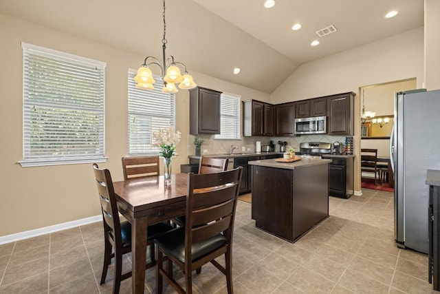 2217 Hilltop Climb Dr, Leander, TX 78641 - kitchen featuring stainless steel appliances, a chandelier, a kitchen island, dark brown cabinets, and decorative backsplash