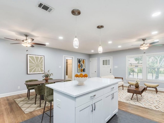 1316 Arcadia Ave, Austin, TX 78757 - kitchen with a ceiling fan, a center island, hanging light fixtures, recessed lighting, and white cabinetry