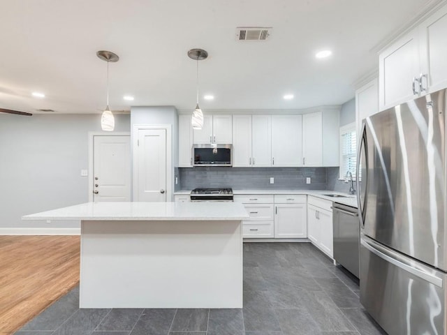 1316 Arcadia Ave, Austin, TX 78757 - kitchen featuring appliances with stainless steel finishes, a sink, light countertops, backsplash, and white cabinetry