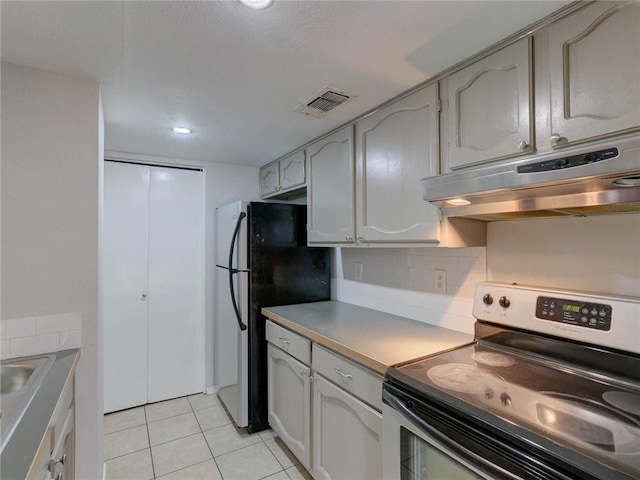 1710 Cinnamon Path, Austin, TX 78704 - kitchen with stainless steel appliances, under cabinet range hood, light tile patterned flooring, backsplash, and light countertops