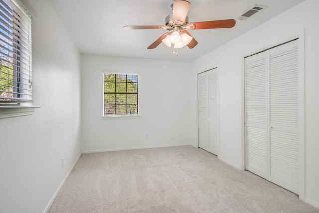 10300 Parkfield Dr, Austin, TX 78758 - unfurnished bedroom featuring two closets, carpet flooring, and a ceiling fan