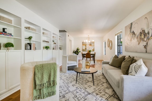 10300 Parkfield Dr, Austin, TX 78758 - living room featuring wood finished floors, a chandelier, and built in features