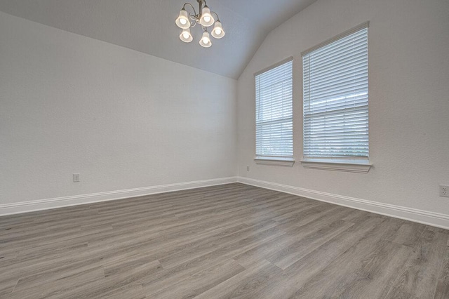 20908 Akbash Ln, Pflugerville, TX 78660 - unfurnished room with lofted ceiling, a chandelier, and wood finished floors