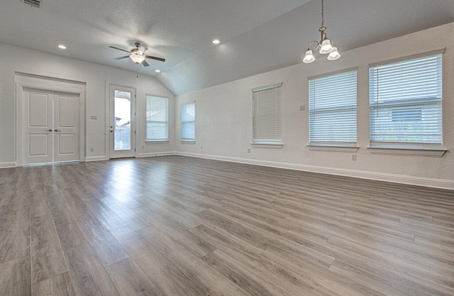 20908 Akbash Ln, Pflugerville, TX 78660 - unfurnished living room with ceiling fan, wood finished floors, lofted ceiling, and a chandelier