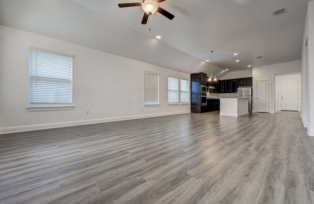 20908 Akbash Ln, Pflugerville, TX 78660 - unfurnished living room featuring lofted ceiling, a ceiling fan, and wood finished floors