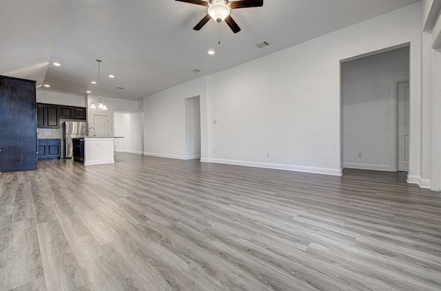20908 Akbash Ln, Pflugerville, TX 78660 - unfurnished living room with ceiling fan, light wood-style floors, and recessed lighting