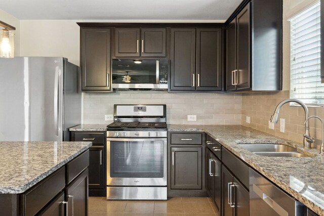 4608 Cleto St, Austin, TX 78725 - kitchen with stainless steel appliances, a sink, backsplash, light stone countertops, and light tile patterned flooring