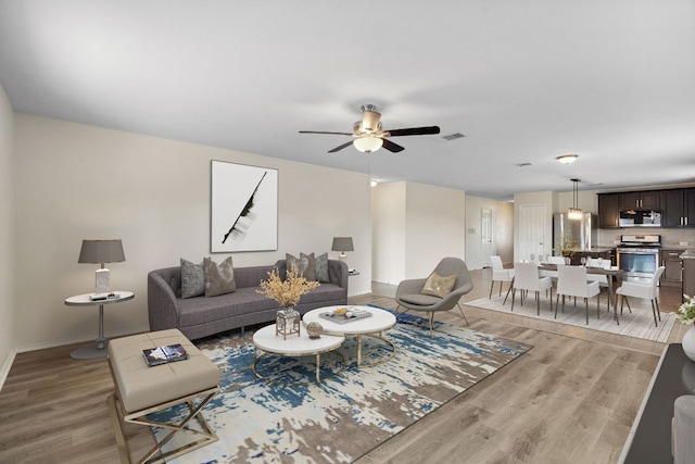 4608 Cleto St, Austin, TX 78725 - living area featuring light wood-style flooring, a ceiling fan, and baseboards