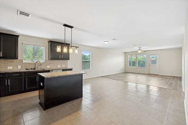 4608 Cleto St, Austin, TX 78725 - kitchen featuring ceiling fan, open floor plan, a sink, tasteful backsplash, and a kitchen island