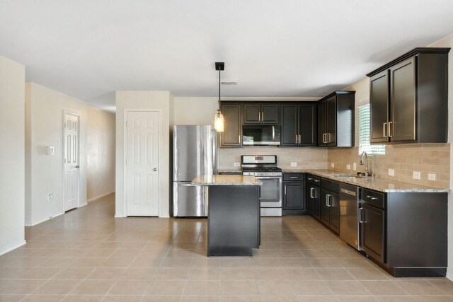 4608 Cleto St, Austin, TX 78725 - kitchen featuring stainless steel appliances, a sink, decorative backsplash, light stone countertops, and a center island