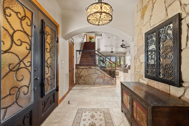 507 Sandy Mountain Dr, Sunrise Beach, TX 78643 - entrance foyer with arched walkways, ceiling fan, stairway, and baseboards