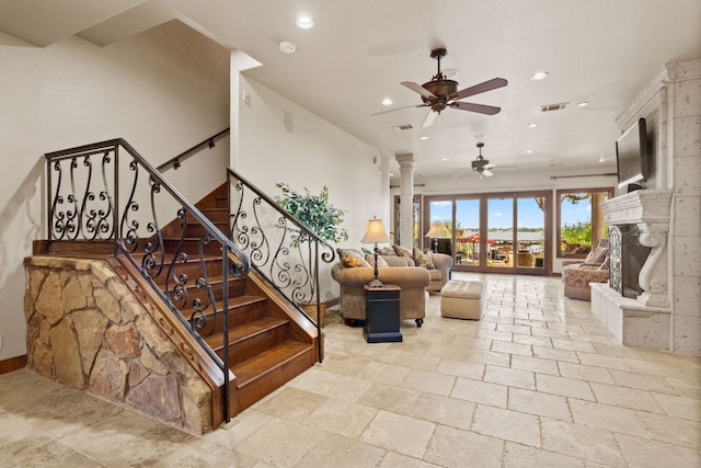 507 Sandy Mountain Dr, Sunrise Beach, TX 78643 - staircase with ceiling fan, recessed lighting, stone tile flooring, ornate columns, and a fireplace with raised hearth