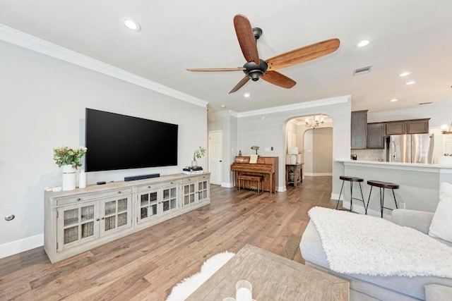 2407 Powderham Ln S, Cedar Park, TX 78613 - living room with arched walkways, ornamental molding, a ceiling fan, baseboards, and light wood finished floors