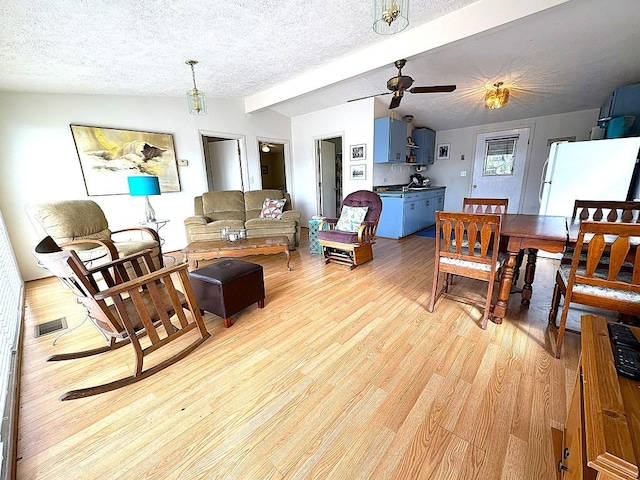 315 Skyline Dr, Sunrise Beach, TX 78643 - living area featuring a textured ceiling, light wood-style flooring, and a ceiling fan