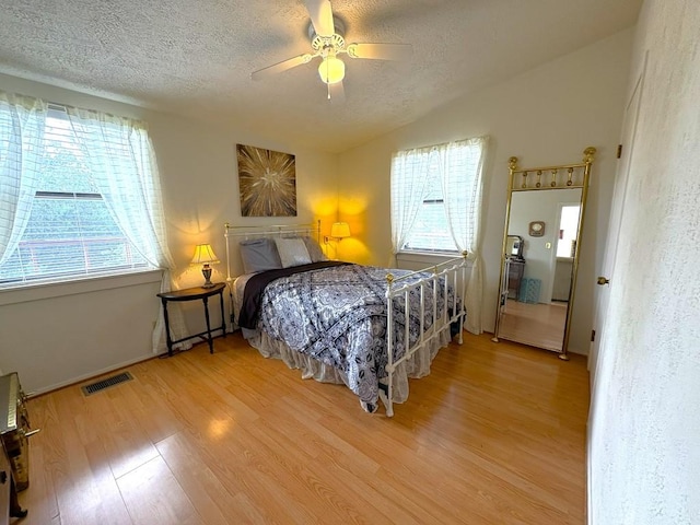 315 Skyline Dr, Sunrise Beach, TX 78643 - bedroom with a textured ceiling, light wood-type flooring, vaulted ceiling, ceiling fan, and baseboards