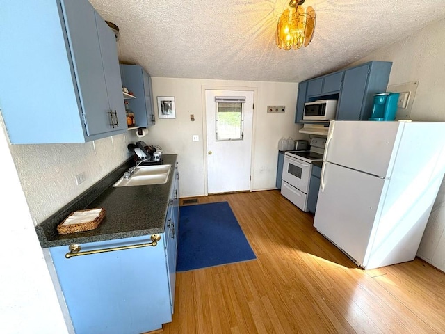 315 Skyline Dr, Sunrise Beach, TX 78643 - kitchen with white appliances, blue cabinetry, a sink, light wood-style flooring, and a textured ceiling