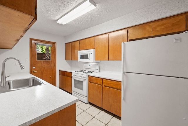2309 Westoak Dr, Austin, TX 78704 - kitchen with white appliances, a sink, light countertops, brown cabinets, and a textured ceiling