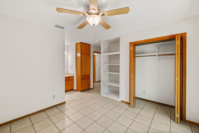 2309 Westoak Dr, Austin, TX 78704 - unfurnished bedroom featuring baseboards, a closet, a textured ceiling, and light tile patterned flooring