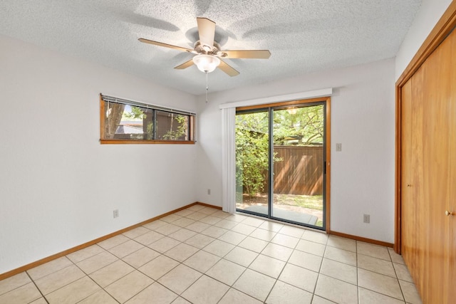 2309 Westoak Dr, Austin, TX 78704 - unfurnished room featuring a textured ceiling, a ceiling fan, light tile patterned floors, and baseboards