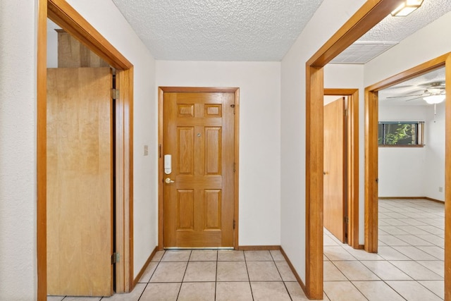 2309 Westoak Dr, Austin, TX 78704 - hall with light tile patterned floors, a textured ceiling, and baseboards