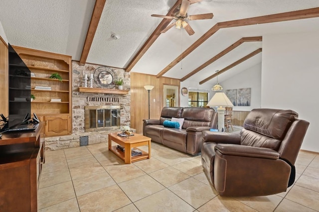 300 W Sequoia Spur, Georgetown, TX 78628 - living area featuring light tile patterned floors, beamed ceiling, a ceiling fan, a textured ceiling, and a stone fireplace