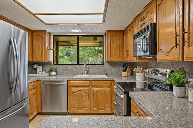300 W Sequoia Spur, Georgetown, TX 78628 - kitchen featuring stainless steel appliances, a sink, brown cabinetry, and tasteful backsplash