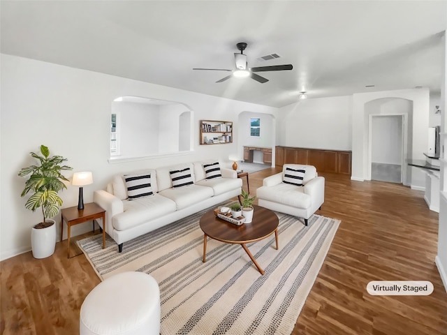 126 Waterlily Way, Hutto, TX 78634 - living room featuring a ceiling fan, arched walkways, and wood finished floors
