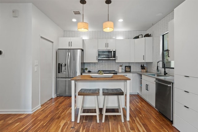 2001 Whitebead Trl, Austin, TX 78734 - kitchen featuring appliances with stainless steel finishes, butcher block countertops, a sink, backsplash, and white cabinetry