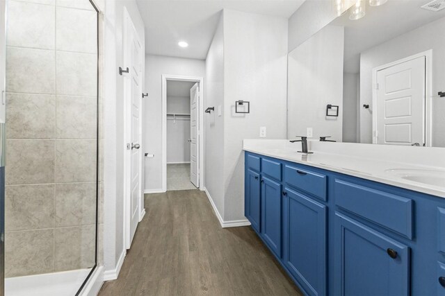 223 Hunters Brk, San Antonio, TX 78253 - full bathroom featuring a stall shower, double vanity, wood finished floors, a walk in closet, and baseboards