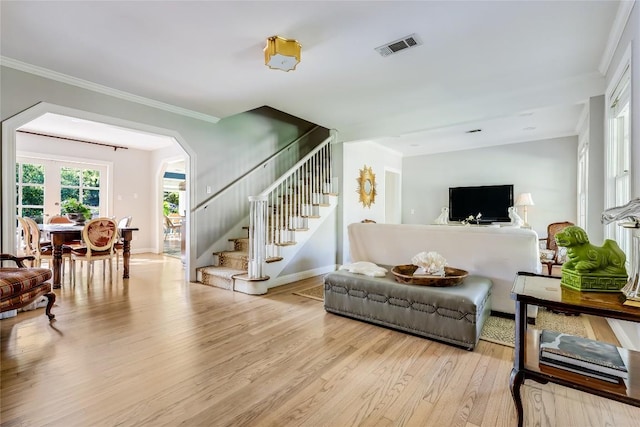 3202 Beverly Rd, Austin, TX 78703 - living room featuring stairs, light wood-style flooring, arched walkways, and ornamental molding