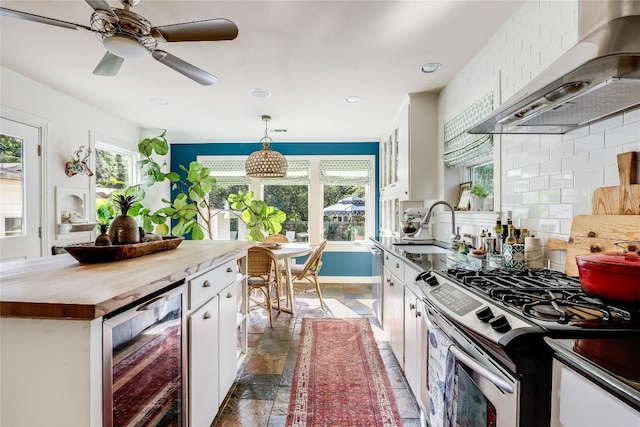 3202 Beverly Rd, Austin, TX 78703 - kitchen with beverage cooler, wall chimney range hood, appliances with stainless steel finishes, stone tile flooring, and white cabinetry