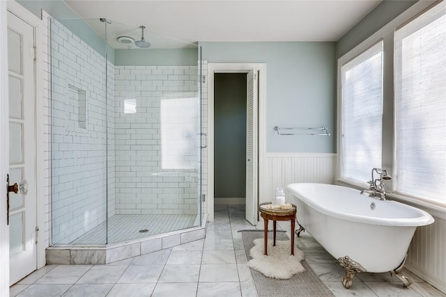 3202 Beverly Rd, Austin, TX 78703 - bathroom with a shower stall, plenty of natural light, a freestanding bath, a wainscoted wall, and marble finish flooring