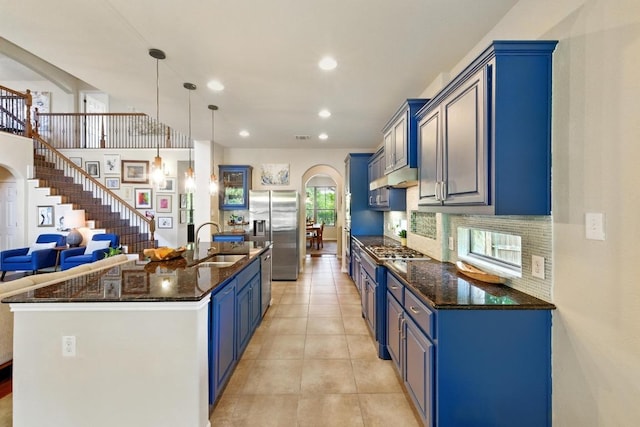 601 Harris Dr, Austin, TX 78737 - kitchen featuring appliances with stainless steel finishes, a sink, arched walkways, blue cabinets, and recessed lighting