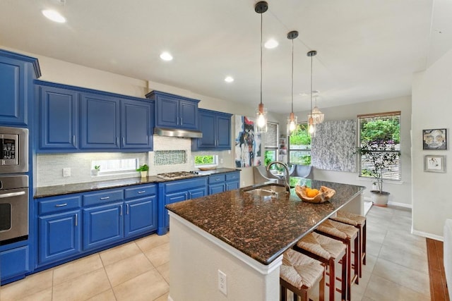 601 Harris Dr, Austin, TX 78737 - kitchen featuring a sink, appliances with stainless steel finishes, blue cabinetry, a kitchen breakfast bar, and tasteful backsplash