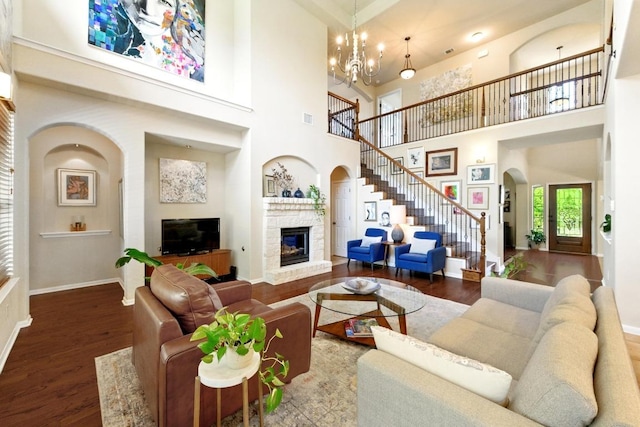 601 Harris Dr, Austin, TX 78737 - living area featuring stairs, a fireplace, wood finished floors, arched walkways, and baseboards