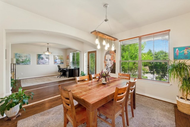 601 Harris Dr, Austin, TX 78737 - dining room with arched walkways, wood finished floors, a chandelier, and baseboards