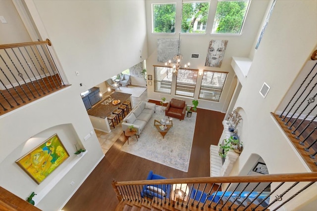 601 Harris Dr, Austin, TX 78737 - living room with a high ceiling, wood finished floors, a chandelier, stairs, and a fireplace