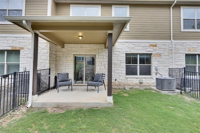 516 E Slaughter Ln Unit 2303, Austin, TX 78744 - rear view of house featuring stone siding, central AC, and a patio