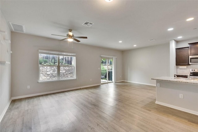516 E Slaughter Ln Unit 2303, Austin, TX 78744 - unfurnished living room featuring ceiling fan, light wood-style floors, baseboards, and recessed lighting