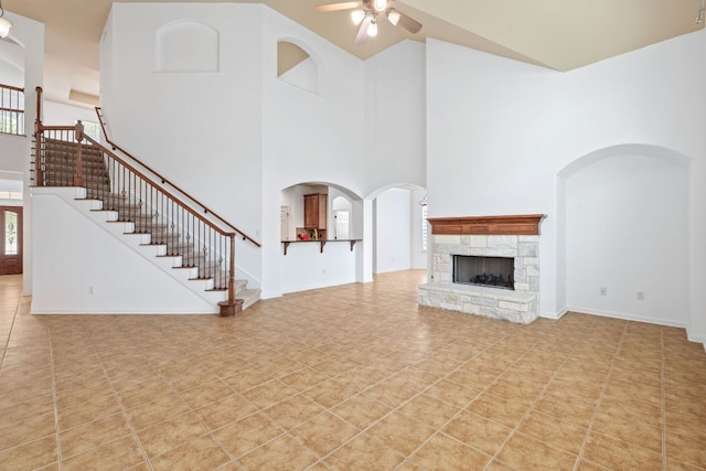16304 Fincastle Dr, Austin, TX 78717 - unfurnished living room with ceiling fan, a high ceiling, stairway, a fireplace, and light tile patterned flooring