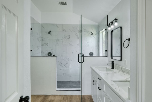 2106 Lobelia Dr, Cedar Park, TX 78613 - bathroom with a marble finish shower, double vanity, lofted ceiling, and wood finished floors