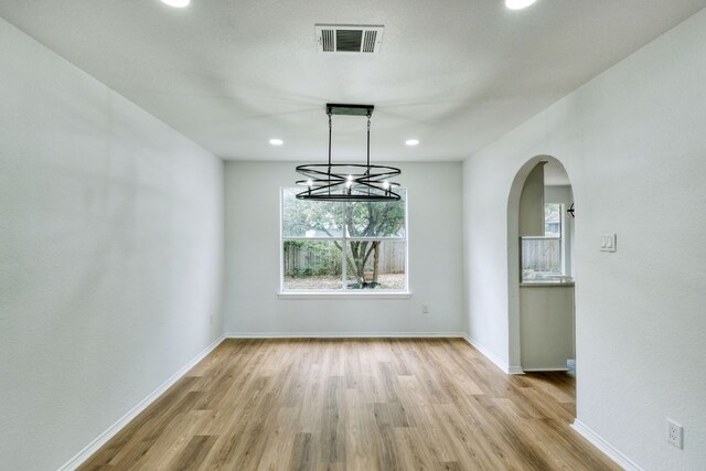 2106 Lobelia Dr, Cedar Park, TX 78613 - unfurnished dining area featuring wood finished floors, arched walkways, baseboards, recessed lighting, and a chandelier