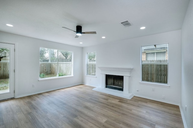 2106 Lobelia Dr, Cedar Park, TX 78613 - unfurnished living room featuring ceiling fan, a fireplace with raised hearth, wood finished floors, baseboards, and recessed lighting
