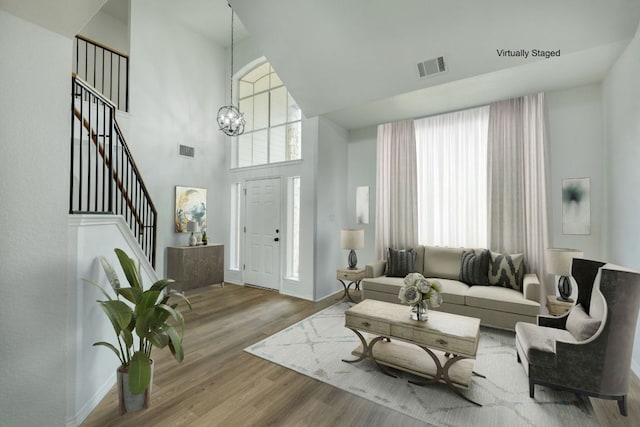 2106 Lobelia Dr, Cedar Park, TX 78613 - living area with a towering ceiling, wood finished floors, a chandelier, baseboards, and stairs