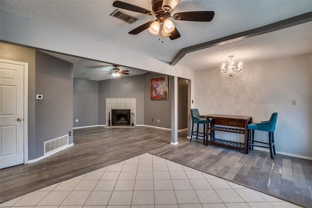 6009 Baton Rouge Dr, Austin, TX 78727 - living area featuring wood finished floors, ceiling fan, baseboards, a textured ceiling, and a tiled fireplace
