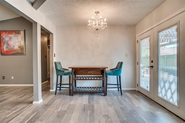6009 Baton Rouge Dr, Austin, TX 78727 - dining room featuring a textured ceiling, wood finished floors, a chandelier, french doors, and baseboards
