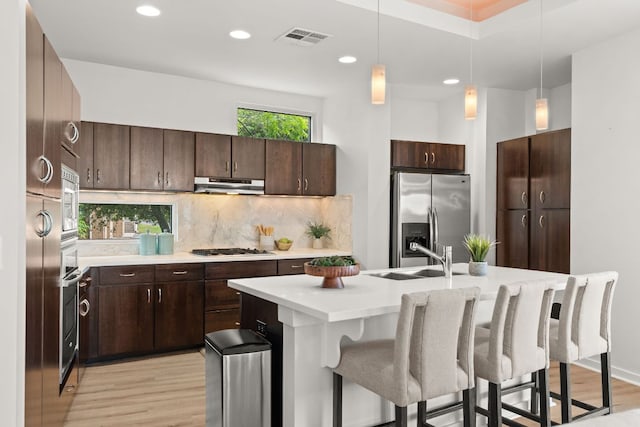 1500 Summit St Unit 4, Austin, TX 78741 - kitchen featuring stainless steel appliances, a sink, under cabinet range hood, light wood finished floors, and recessed lighting